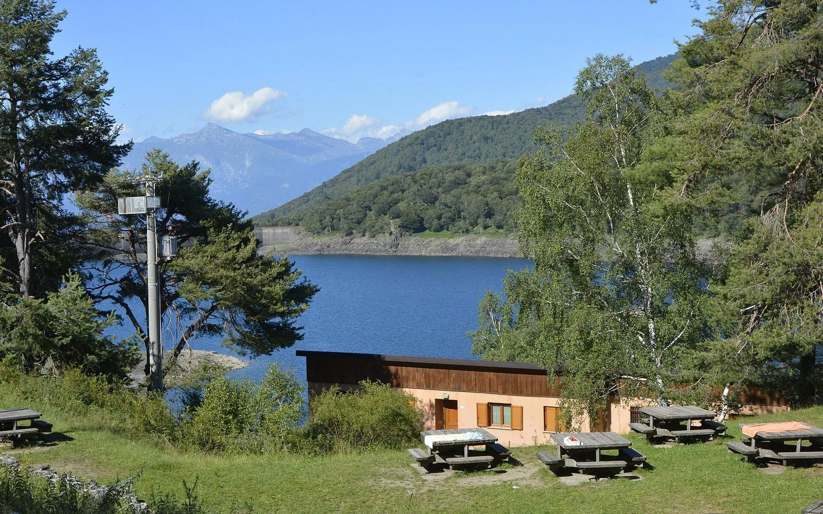 Il Lago Delio circondato dai boschi, con l'area di sosta sulla riva
